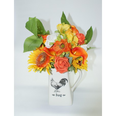 Ceramic Jug Arranged with Mixed Orange and Yellow Shades of Flowers with Greenery